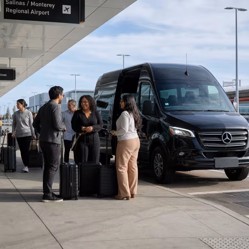 Group boarding a white charter bus for Airport Transportation transportation in Salinas